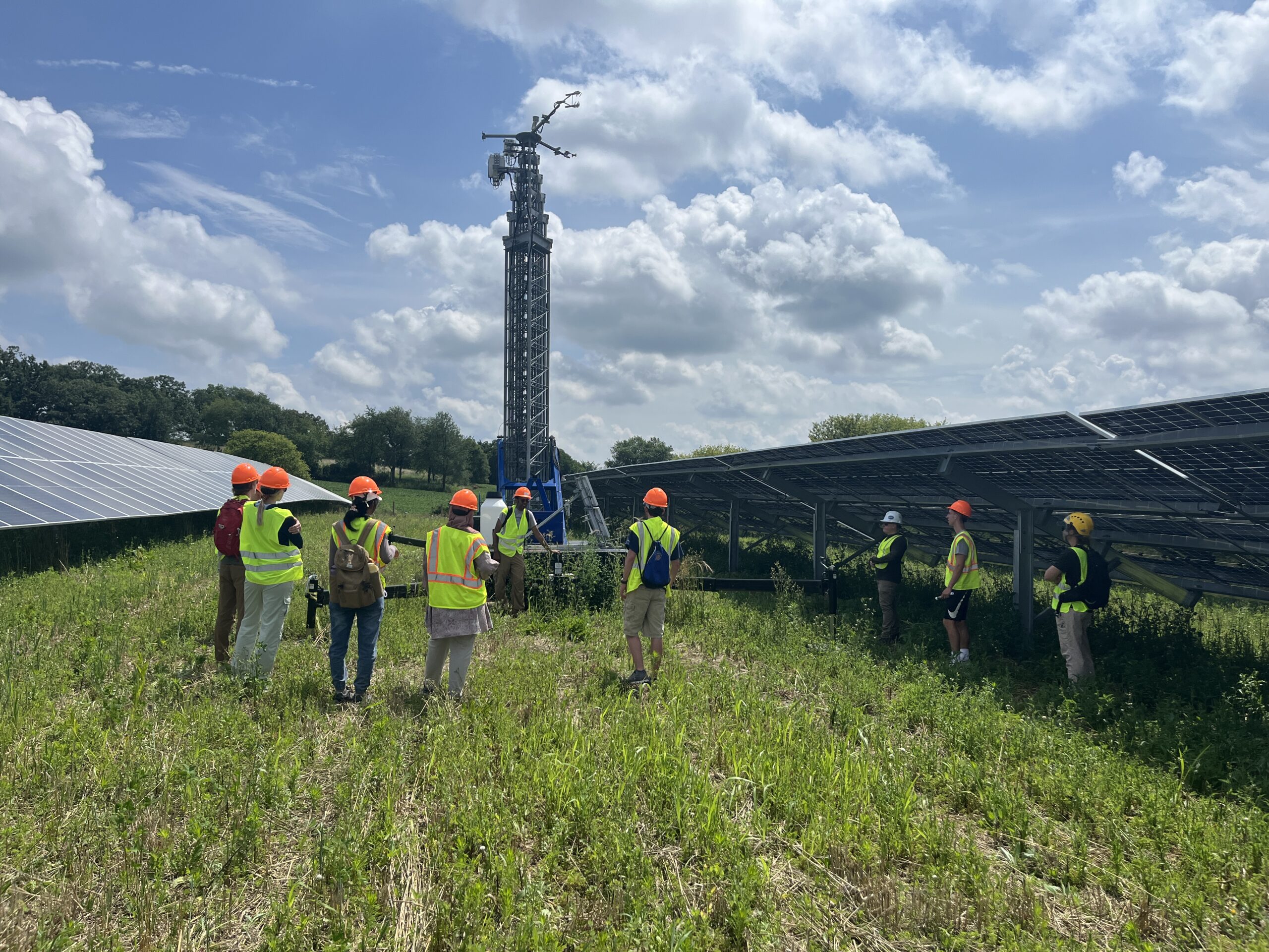 Students touring flexible solar tracker array and meteorological tower